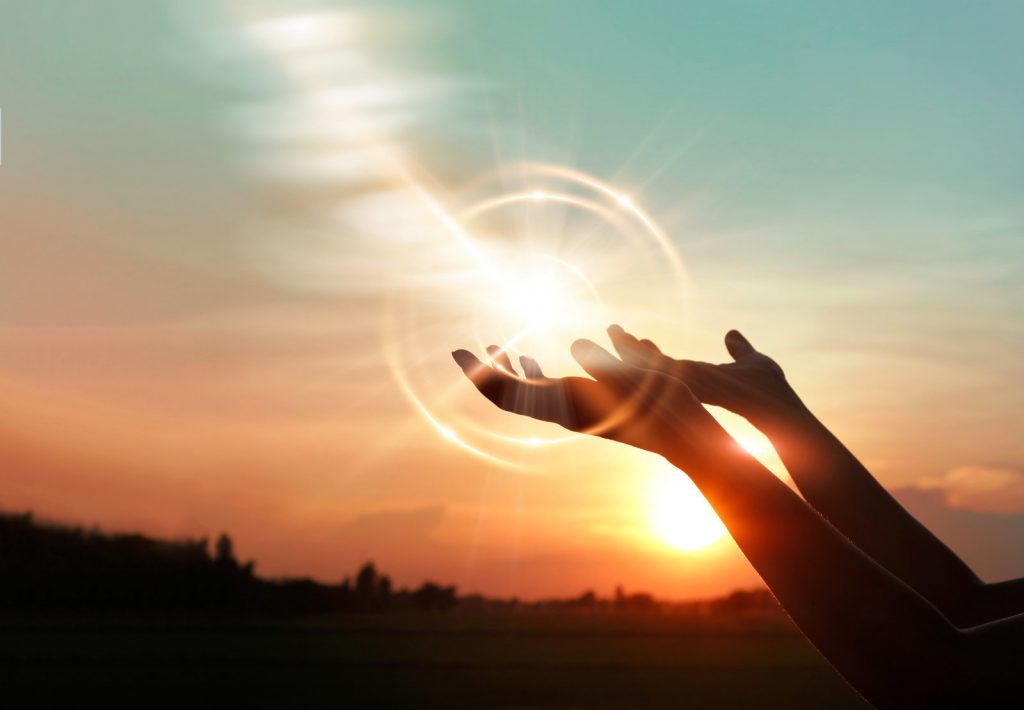 Woman hands praying for blessing from god on sunset background Woman hands praying for blessing from god on sunset background